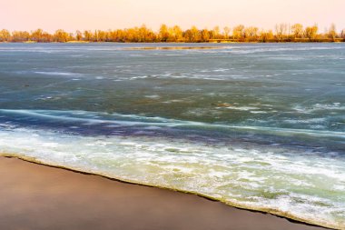 Donmuş Dnieper Nehri üzerinde Kiev bir soğuk kış aylarında buz blokları. Ağaçlar uzaktan görünür.