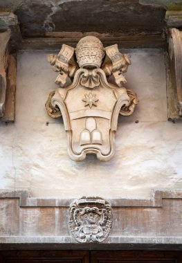 Arması Papa Clement XI yukarıda bir kapı İtalya Sassocorvaro şehir içinde. Clement XI sanat ve bilimin bir patron oldu. Ayrıca Vatikan Kütüphane büyük bir hayırsever oldu