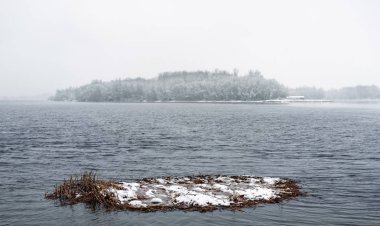 Soğuk ve karlı kış günü sırasında Dnieper Nehri manzarası. Gökyüzü bulutlar tarafından kaplıdır ve kar pul yumuşak ağaçlarda ve yere düşmek