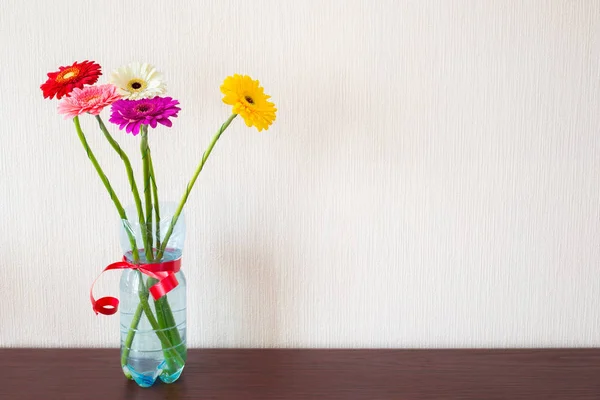 Πέντε Πολύχρωμα Λουλούδια Gerbera Ένα Μπουκάλι Νερό Plasctic Μια Κόκκινη — Φωτογραφία Αρχείου