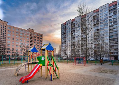 Gün batımında yüksek binalar arasında bahçedeki çocuklar için Myszków/Ukrayna - 26 Şubat 2012 - açık hava oyunları