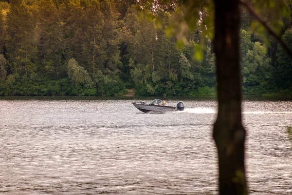 夏の初めに ウクライナのキエフのドニエプル川の森の前を黒と白のスピードボートが通過します — ストック写真