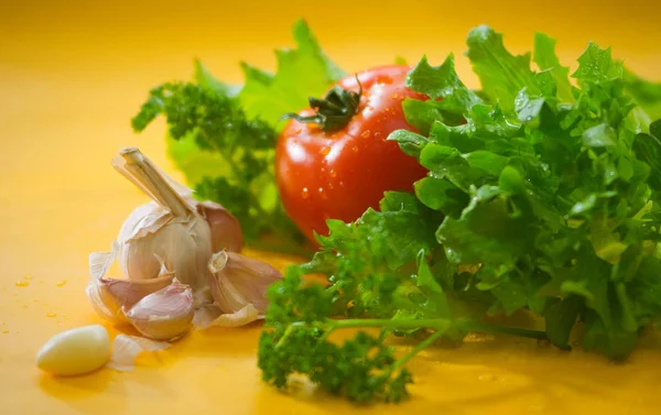 Zöldség Paradicsom Gerezd Fokhagyma Zöld Saláta Vízcseppek Elmosódott Sárga Háttérrel — Stock Fotó