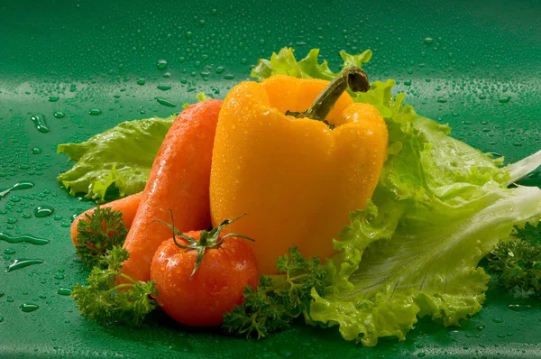 野菜のニンジン トマト 黄色ピーマンを洗ってレタスの葉 パセリの水滴と緑の背景 — ストック写真