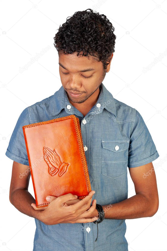 Young Indo-Mauritian or Creole Pastor in training holding a bible lovingly. Portrait format isolated on white background. Inspiration for poster with copy space for devotion, prayer circle or faith.