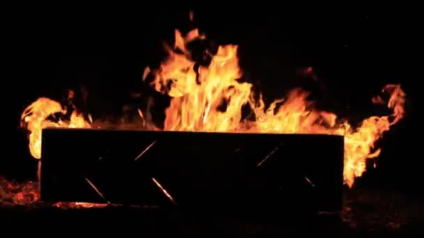 Sem som. Close-up vídeo de um banco de piquenique em chamas no final de uma festa. Férias de verão divertido ou destruição maliciosa da propriedade. Fúria de chamas dançantes e calor intenso contra a escuridão da noite — Vídeo de Stock