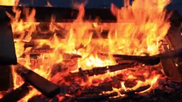 Kein Ton. 25 25 Sekunden. Extreme Nahaufnahme brennender Picknickbänke am Ende einer Party. Sommerferienspaß oder mutwillige Zerstörung von Eigentum. wütende tanzende Flammen und intensive Hitze — Stockvideo