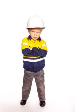 Sarışın, beyaz çocuk kollarını katlamış sarı ve mavi bir yüksek çözünürlüklü gömlek, çizmeler, beyaz bir şapka, çekiç ve mezura ile kızgın bir inşaat işçisi rolü oynuyor..