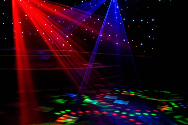 Helle Nachtclub-Laserlichter, die sich durch den Rauch der Rauchmaschine schneiden und Licht und Regenbogenmuster auf der Tanzfläche erzeugen. Laserlichter mit Bokeh im Hintergrund. Inspiration für Mardi Gras oder Nightlcub Promotions. — Stockfoto