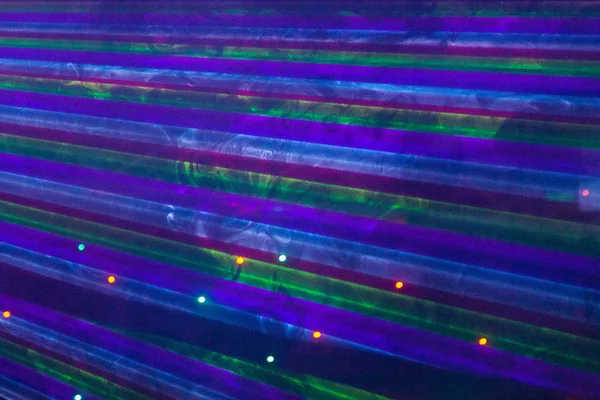 Helle Nachtclub-Laserlichter, die sich durch den Rauch der Rauchmaschine schneiden und Licht und Regenbogenmuster auf der Tanzfläche erzeugen. Laserlichter mit Bokeh im Hintergrund. Inspiration für Mardi Gras oder Nightlcub Promotions. — Stockfoto