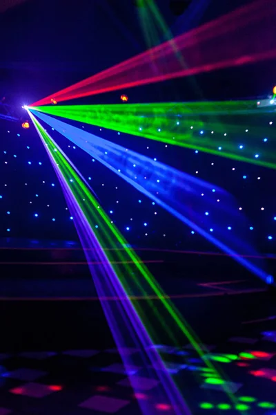 Lumières laser de boîte de nuit lumineuses coupant à travers la fumée de la machine à fumée créant des motifs légers et arc-en-ciel sur la piste de danse. Lumières laser avec bokeh en arrière-plan. Inspiration pour les promotions Mardi Gras ou nightlcub . — Photo