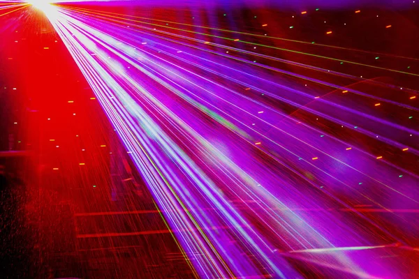 Bright nightclub laser lights cutting through smoke machine smoke making light and rainbow patterns on the dance floor. Laser lights with bokeh in the background. Inspiration for Mardi Gras or nightlcub promotions.