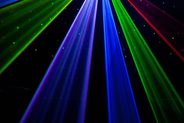 Helle Nachtclub-Laserlichter, die sich durch den Rauch der Rauchmaschine schneiden und Licht und Regenbogenmuster auf der Tanzfläche erzeugen. Laserlichter mit Bokeh im Hintergrund. Inspiration für Mardi Gras oder Nightlcub Promotions. lizenzfreie Stockfotos