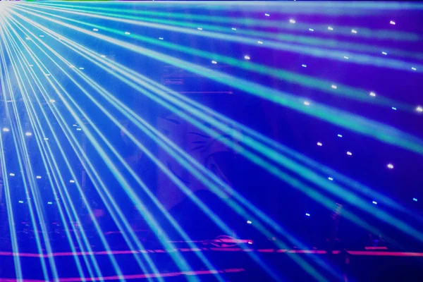 Helle Nachtclub-Laserlichter, die sich durch den Rauch der Rauchmaschine schneiden und Licht und Regenbogenmuster auf der Tanzfläche erzeugen. Laserlichter mit Bokeh im Hintergrund. Inspiration für Mardi Gras oder Nightlcub Promotions. Stockbild