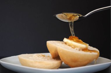 Ekmek rulo tereyağı ve bal ile kahvaltıda