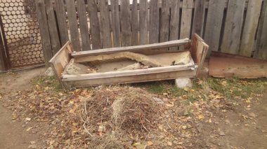 Yaşlılıktan çökmüş ve açık havada sokakta duran eski bir kanepenin fotoğrafı.