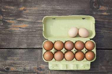 doğrudan yukarıdaki vurdu ahşap bir masa üzerinde bir karton kutu içinde yumurta alanı Kopyala