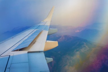 Uçak pencere gökkuşağı etkisi ile havadan dağ manzarası