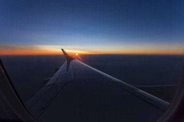 Pembe şafak ışık üstünde belgili tanımlık bulut uçak kanadı altında