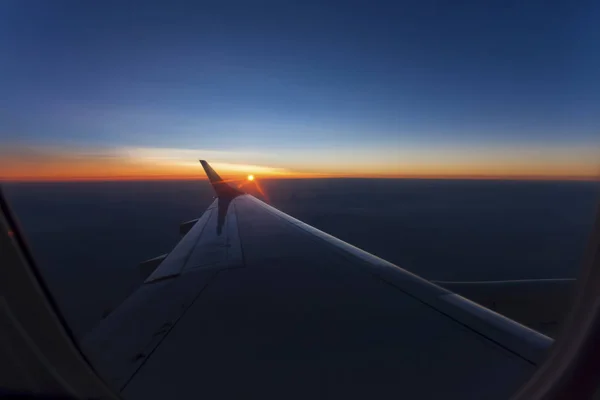飞机机翼下的云上的粉红色黎明光 — 图库照片