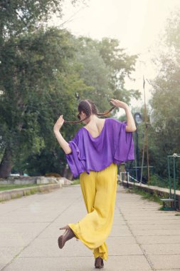 Genç ve güzel kadın için kamera parkta arkadan süre poz dalga geçmeyi