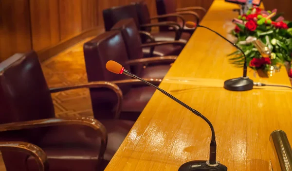 Close up of microphones and empty chairs in conference hall ready for public speaking. Academic gathering