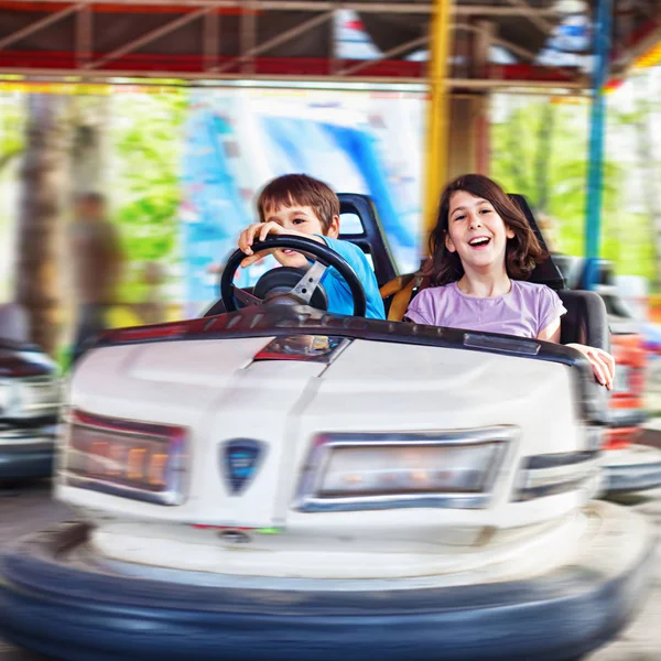 İki çocuk, gülüyor, eğleniyor bir çarpışan araba hareket bulanıklığı