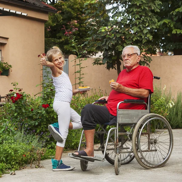 8 year old happy granddaughter helping her disabled grandfather outside