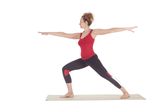 Beautiful Yoga: Warrior pose two - Real senior sporty woman practitioner doing Virabhadrasana 2 exercise