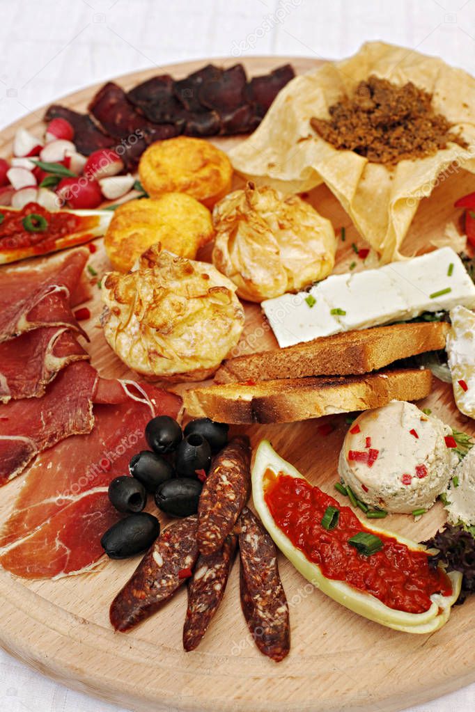Serbian cheese and meat appetizer plate includes homemade white cheese, traditional corn bread, and prosciutto (prsut) ham - finger food -  cold buffet