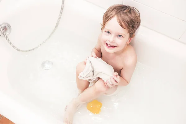 Happy 5 year old playing in a bathtub — Stock Photo, Image