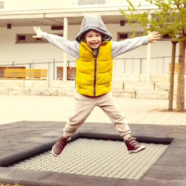 Ευτυχισμένο αγόρι υψηλά άλματα σε τραμπολίνο στο πάρκο — Φωτογραφία Αρχείου