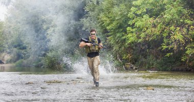 Bir gün komando tüfeğiyle suda yürür.
