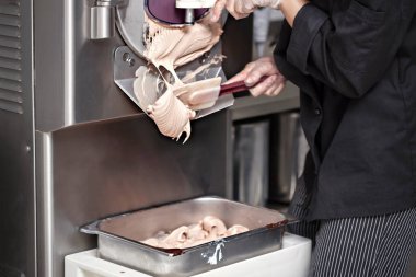 Küçük fabrikadaki dondurma makinesinden nugat dondurma almak.