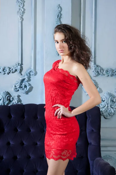 年轻的女人在优雅的红色鸡尾酒礼服摆姿势在豪华的内部 — 图库照片