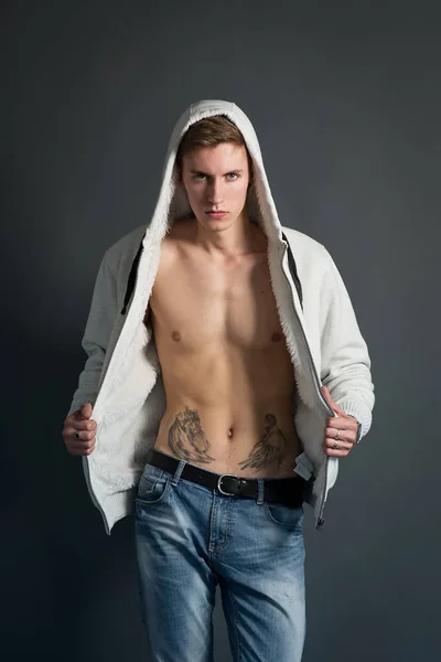 ポーズを黒の背景に白のパーカー 裸の入れ墨胴体で若い男 — ストック写真