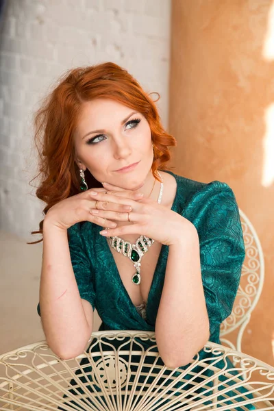 红头发的妇女的肖像在豪华绿色礼服和翡翠首饰 — 图库照片