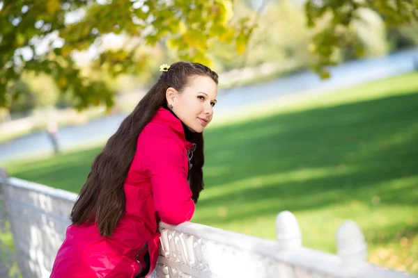 Νεαρή Γυναίκα Που Ποζάρει Δίπλα Φράχτη Στο Ηλιόλουστο Φθινοπωρινό Πάρκο — Φωτογραφία Αρχείου
