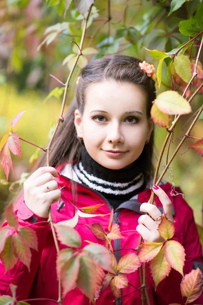 Junge Fröhliche Frau Roten Mantel Posiert Grünen Blättern — Stockfoto