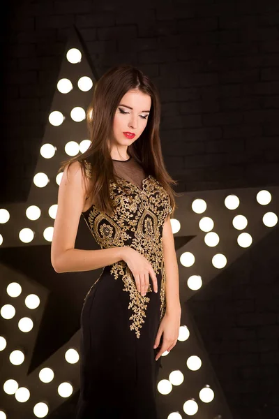 Jovencita Vestido Negro Con Encaje Dorado Sobre Fondo Brillante —  Fotos de Stock