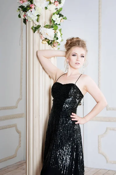 Young woman posing in black sparkling dress