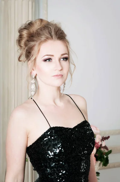 Young woman posing in black sparkling dress