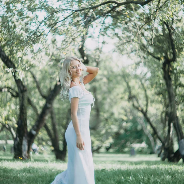 快乐的金发女郎在白色的夏装散步在公园 — 图库照片