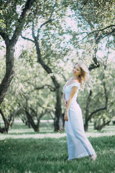 Beyaz Yazlık Elbiseli Mutlu Sarışın Kadın Parkta Yürüyor — Stok fotoğraf