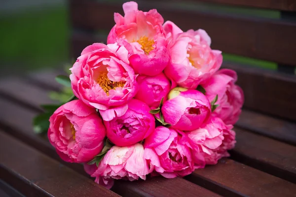 Bouquet of peonies lying on bench