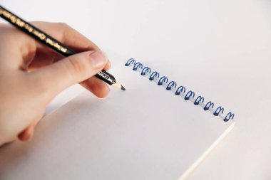 Defter ve kalem beyaz zemin üzerine eliyle. Defter ve kalem ile solak.