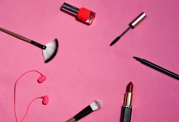 flat lay the tools to create makeup on pink background