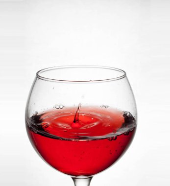 cam kadehi sıvı sıçramasına ile beyaz arka plan üzerinde