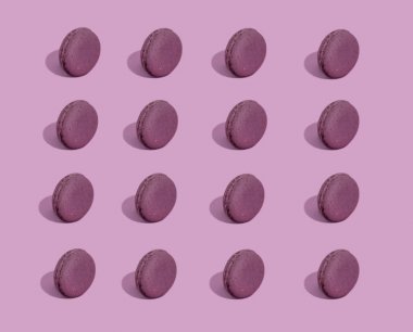 Renkli bir arka plan üzerinde Macaroons, renkli Fransız macarons kurabiye görüntü. Pembe bir arka plan üzerinde Macaron fransız pasta, minimal kavram. Bir sürü makaron, sert ışık, sert gölgeler.