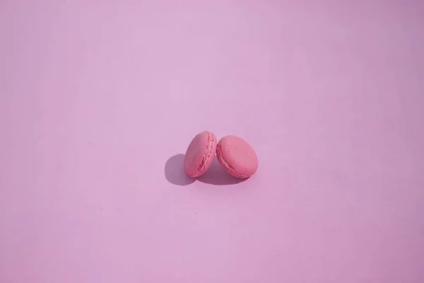 Renkli bir arka plan üzerinde Macaroons, renkli Fransız macarons kurabiye resmi. Pembe arka plan, minimal konsept li makarna Fransız pastası.